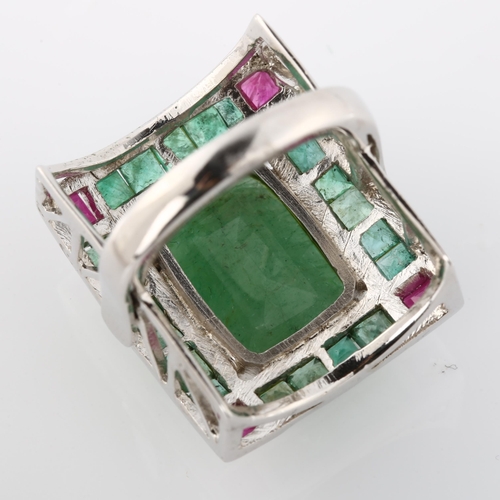 368 - A large emerald and ruby cluster cocktail ring, unmarked white metal settings with openwork bridge, ... 