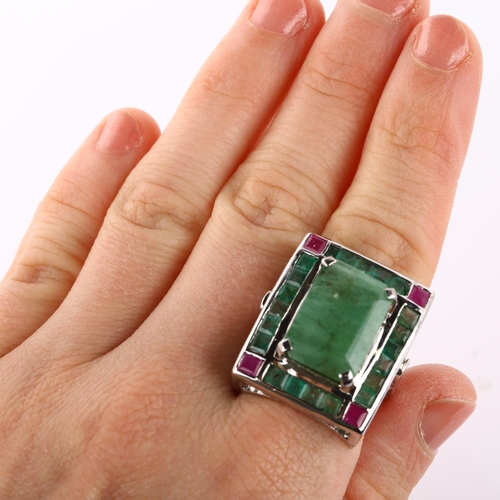 368 - A large emerald and ruby cluster cocktail ring, unmarked white metal settings with openwork bridge, ... 