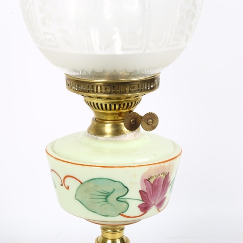 237 - A Victorian and brass oil lamp, with etched clear glass shade and milk glass painted font, on a terr... 