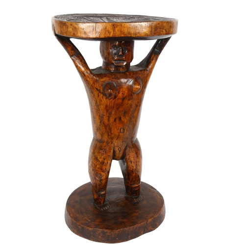 41 - An African hardwood Tribal stool, with carved seat and figural support, height 53cm, width 30cm