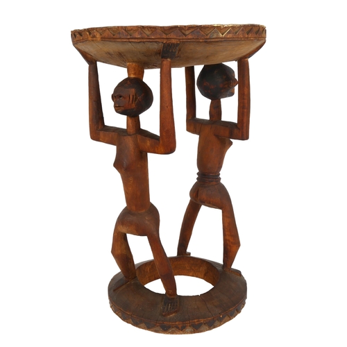 42 - An African hardwood Tribal fertility stool, with painted top and double-figural supports, height 50c... 