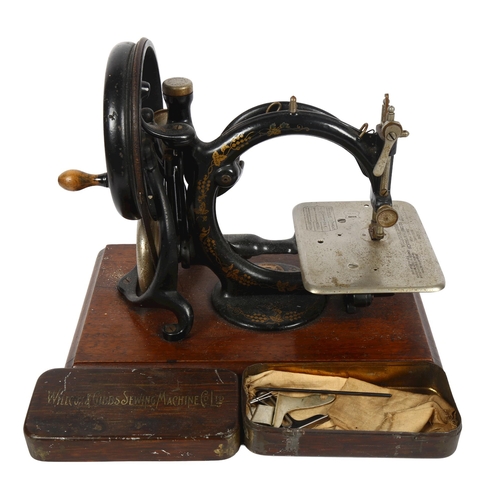 455 - Antique Willcox & Gibbs sewing machine with gilded decoration, on plinth, with original tin for acce... 