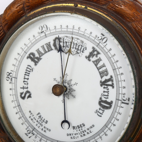 512 - An aneroid barometer in carved oak rope twist surround, 23cm