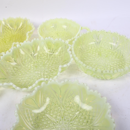 563 - A set of 7 moulded vaseline glass dishes, with shaped rims, largest 20cm across