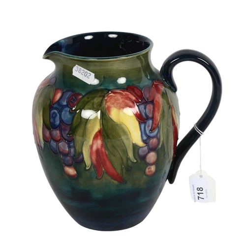 718 - A Moorcroft jug with tube-lined fruit decoration (A/F), signed William Moorcroft, height 20cm