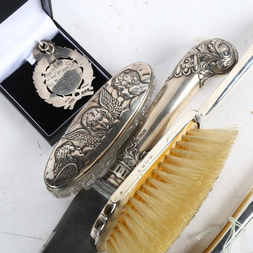 1020 - A silver-backed dressing table brush and mirror, a silver-topped dressing table jar, a pistol-grip s... 