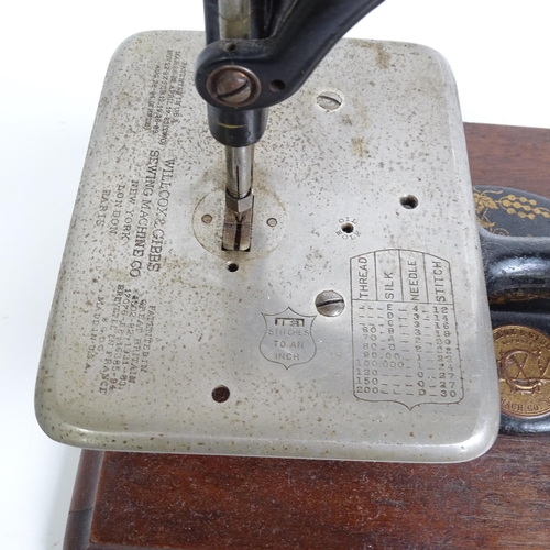 455 - Antique Willcox & Gibbs sewing machine with gilded decoration, on plinth, with original tin for acce... 