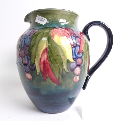 718 - A Moorcroft jug with tube-lined fruit decoration (A/F), signed William Moorcroft, height 20cm