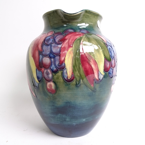 718 - A Moorcroft jug with tube-lined fruit decoration (A/F), signed William Moorcroft, height 20cm