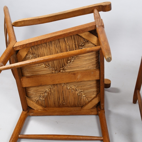 125 - A pair of mid-century ladderback lounge chairs, in oak with rush seats in the Cotswold School Arts a... 