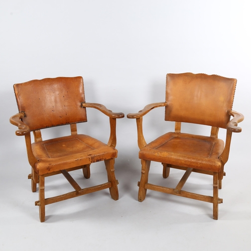 126 - A pair of craftsman made Art and Craft oak armchairs, with leather upholstery, height 81cm