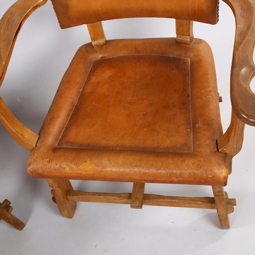 126 - A pair of craftsman made Art and Craft oak armchairs, with leather upholstery, height 81cm