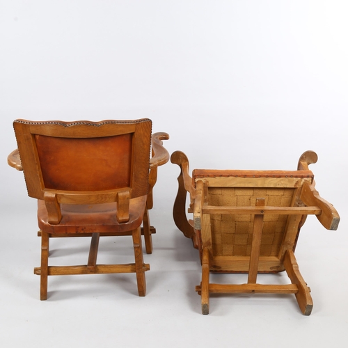 126 - A pair of craftsman made Art and Craft oak armchairs, with leather upholstery, height 81cm