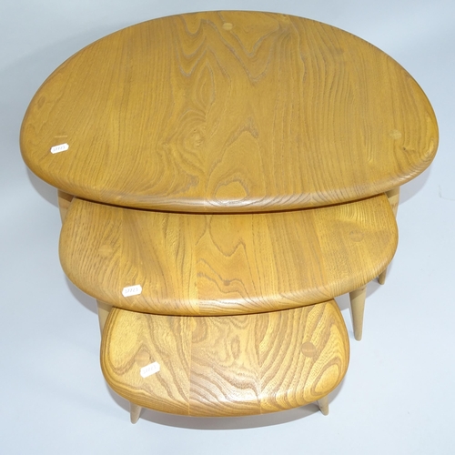 2006 - A mid-century Ercol elm nest of three pebble occasional tables, largest 66cm x 41cm x 45cm