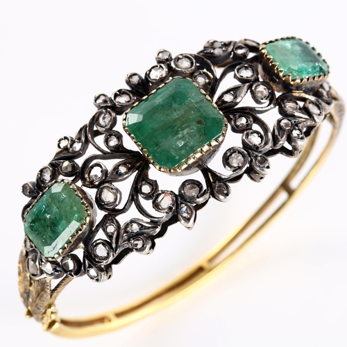 1109 - A fine Victorian emerald and diamond hinged bangle, unmarked gold and silver-topped openwork setting... 