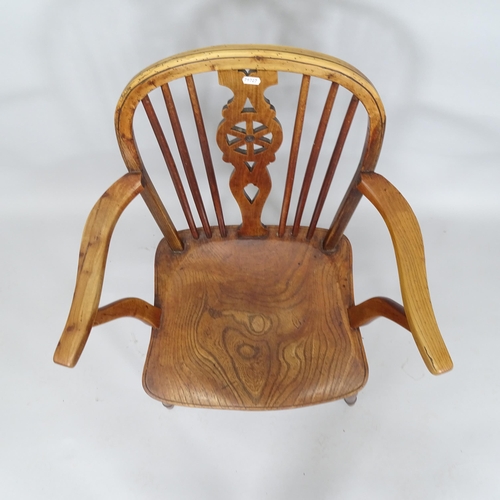 2025 - An early 19th Century elm seated wheel-back elbow chair