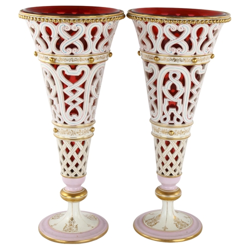 249 - Pair of Bohemian gilded and pierced milk glass vases, with cranberry liners, height 39cm (1 A/F)