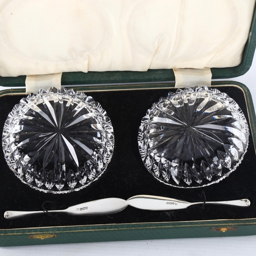 297 - A pair of glass butter dishes, with silver butter knives, hallmarks Sheffield 1937, dish diameter 10... 