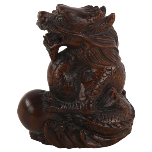 376 - A Chinese carved wood dragon and pearl design netsuke, height 4.5cm