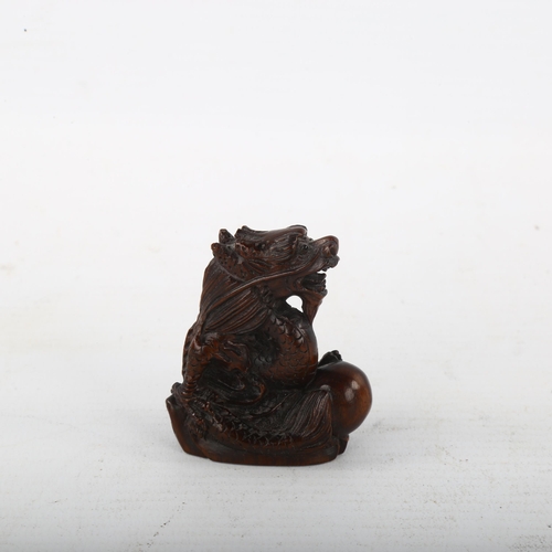 376 - A Chinese carved wood dragon and pearl design netsuke, height 4.5cm