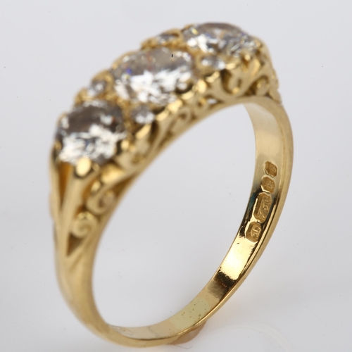 1131 - A late 20th century 18ct gold graduated three stone diamond half hoop ring, set with modern round br... 