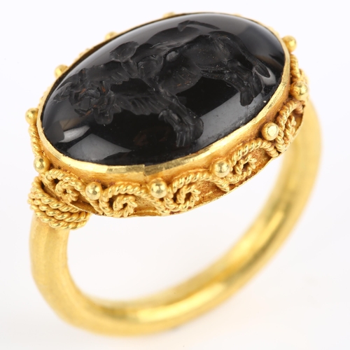 1137 - A Victorian style seal ring, unmarked yellow metal settings with wirework surround and intaglio carv... 