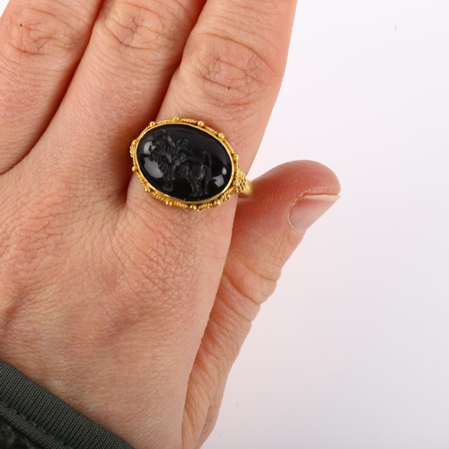 1137 - A Victorian style seal ring, unmarked yellow metal settings with wirework surround and intaglio carv... 