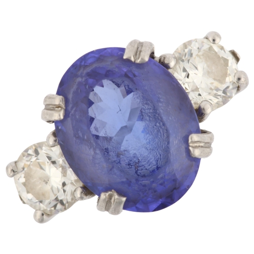 1159 - A platinum three stone tanzanite and diamond ring, set with oval mixed-cut tanzanite and modern roun... 