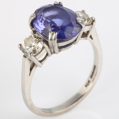 1159 - A platinum three stone tanzanite and diamond ring, set with oval mixed-cut tanzanite and modern roun... 