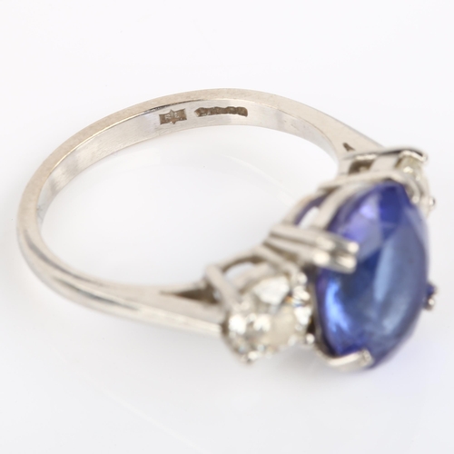 1159 - A platinum three stone tanzanite and diamond ring, set with oval mixed-cut tanzanite and modern roun... 