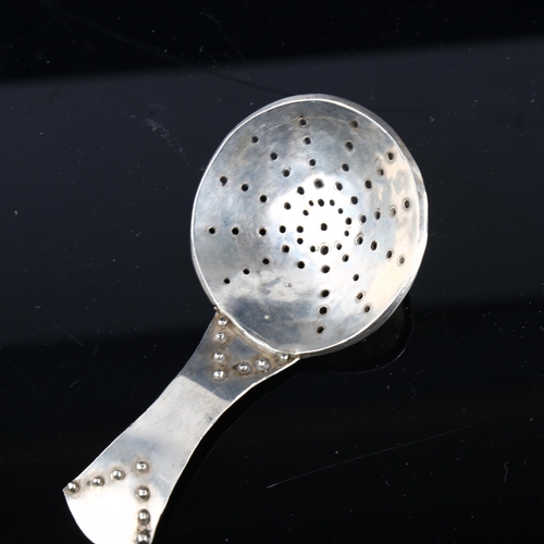 1680 - An Arts and Crafts unmarked silver tea caddy strainer spoon, length 10cm