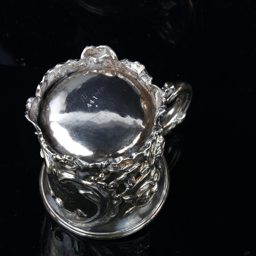 1681 - A Victorian silver half pint christening mug, relief embossed floral decoration with foliate handle,... 