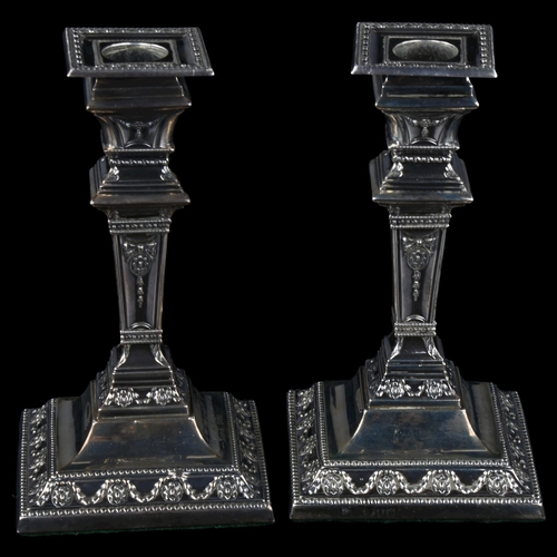 1709 - A pair of Victorian Neo-Classical style silver table candlesticks, square tapered form with relief e... 