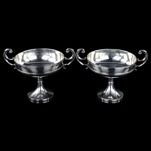 1714 - A pair of Edwardian silver pedestal trophy dishes, circular form with scrolled handles, by S W Smith... 