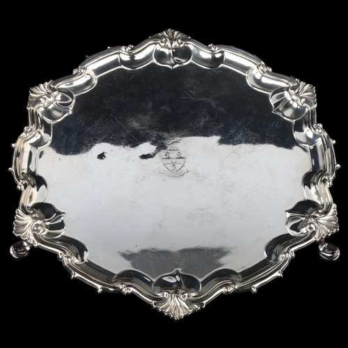 1744 - A George V silver salver, circular form with piecrust edge and foliate border, with engraved armoria... 