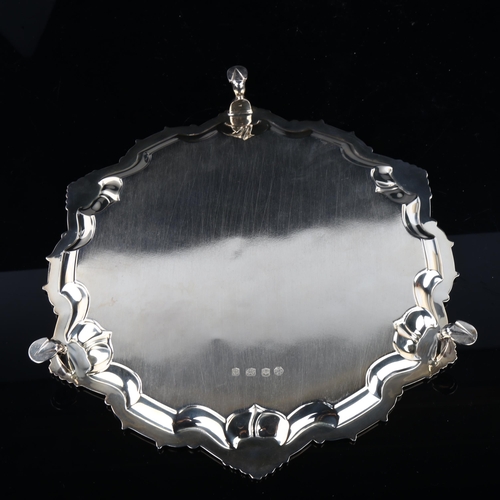 1744 - A George V silver salver, circular form with piecrust edge and foliate border, with engraved armoria... 