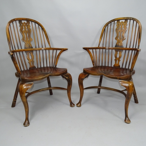 2055 - A pair of Windsor double bow arm chairs, with elm seat and crinoline stretcher