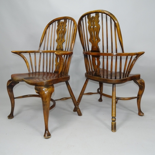 2055 - A pair of Windsor double bow arm chairs, with elm seat and crinoline stretcher