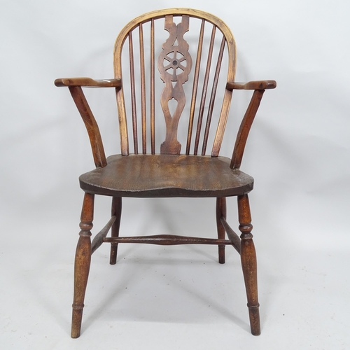 2069 - A 19th Century elm-seated wheelback elbow chair, and an elm seated milking stool (2)