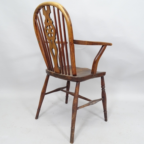 2069 - A 19th Century elm-seated wheelback elbow chair, and an elm seated milking stool (2)