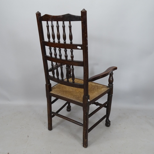 2239 - An Antique mahogany North Country style open-arm chair, with bobbin turned back and rush seat