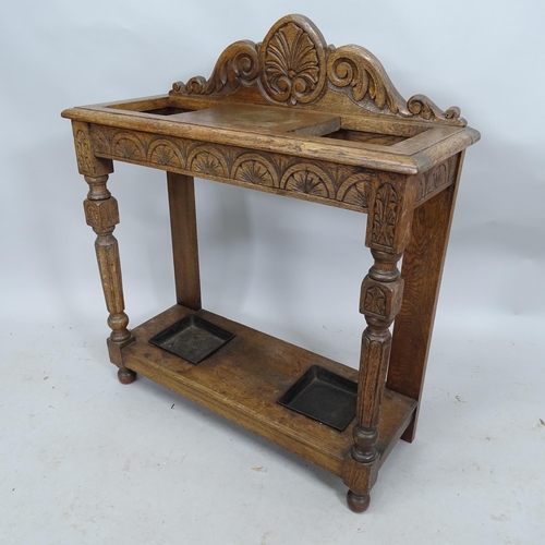 2199 - A carved oak stickstand with all over carved decoration and metal driptrays. 77cm x 88cm x 28cm.