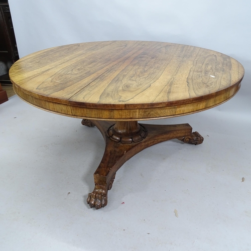 2208 - A William IV rosewood tilt-top centre table raised on a centre column with platform base and lion-pa... 