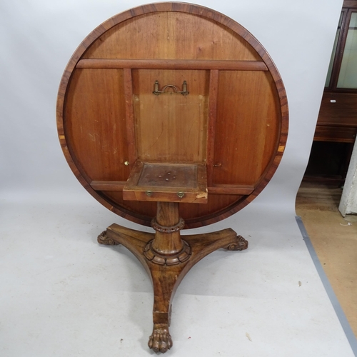 2208 - A William IV rosewood tilt-top centre table raised on a centre column with platform base and lion-pa... 