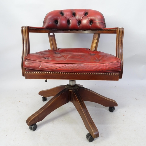 2212 - An early 20th century red leather-upholstered swivel desk chair.