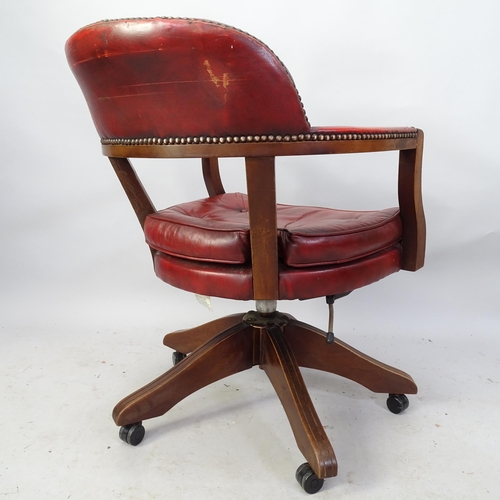 2212 - An early 20th century red leather-upholstered swivel desk chair.