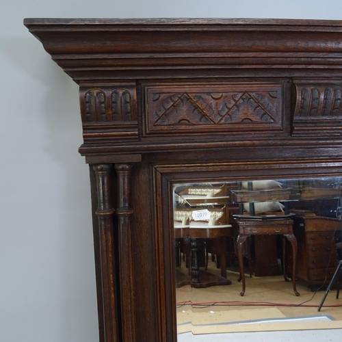 2218 - a 19th century oak framed bevel-edged over-mantle mirror with carved decoration, 98cm x 129cm