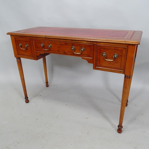 2224 - A reproduction yew-wood writing table with tooled and embossed red leather skiver and three fitted d... 