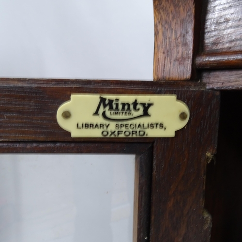 2242 - An early 20th century oak three section Minty bookcase, with maker's label. 90cm x 104cm x 27cm