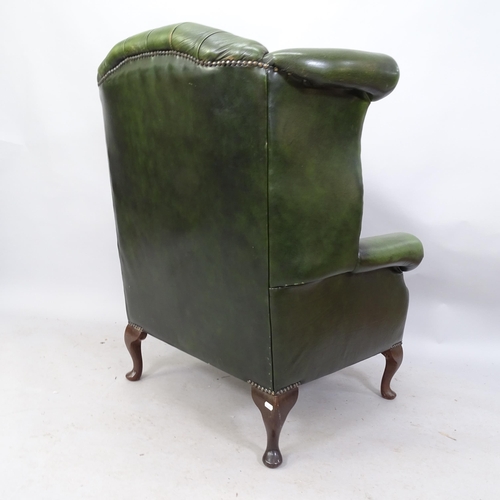 2268 - A Green leather upholstered buttoned wing back fireside armchair 89 x 106 x 80cm and a matched green... 